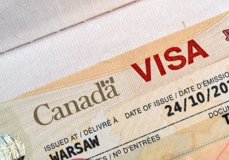 Close-up of a Canadian visa document issued in Warsaw, showing the word “VISA” and part of the issuance date.